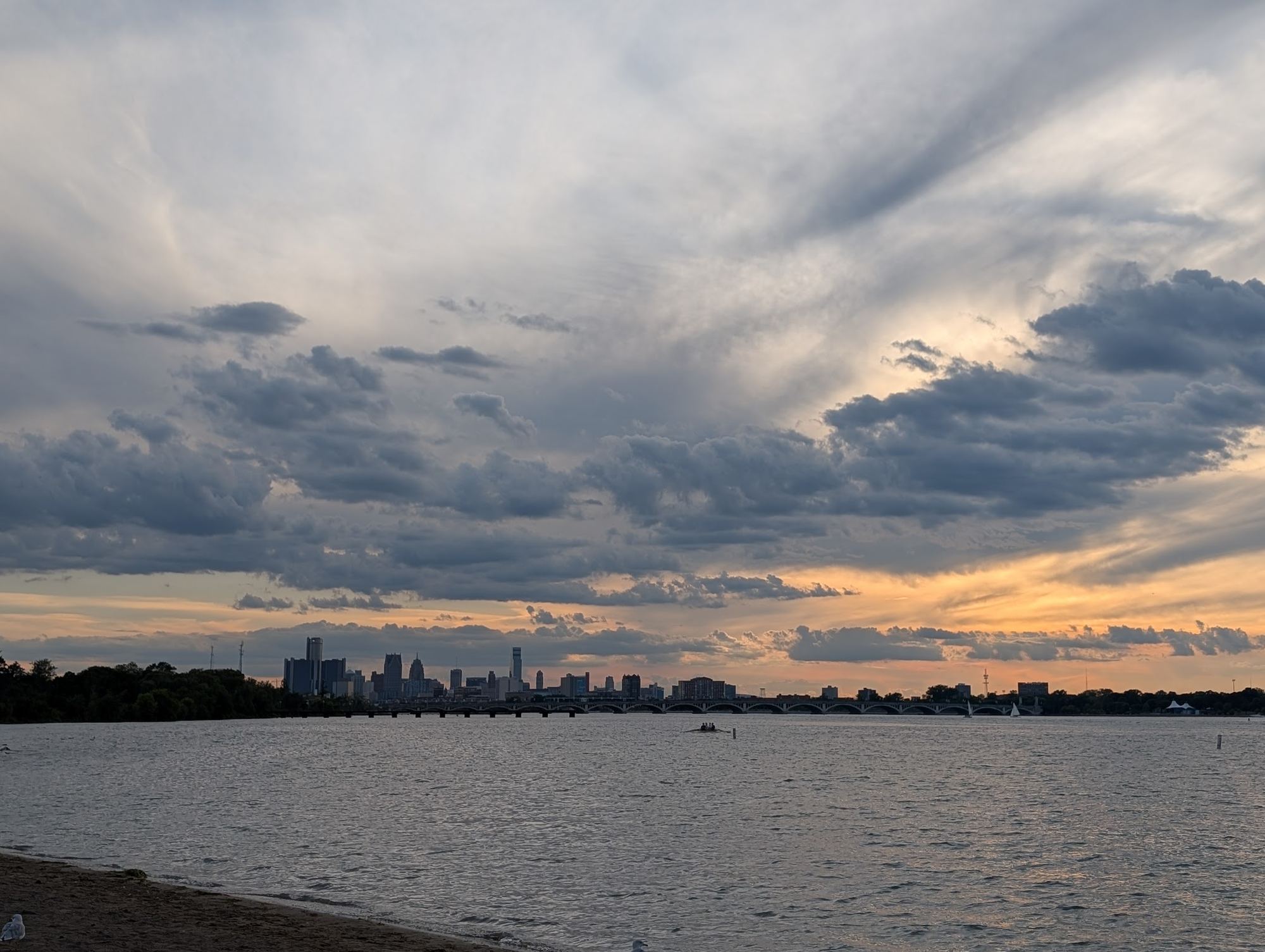 The Detroit skyline across the river under a sunset sky